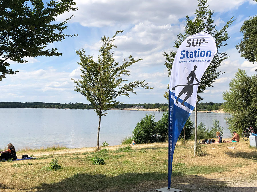 Ein Stand-Up-Paddling Aufsteller steht am Strand.